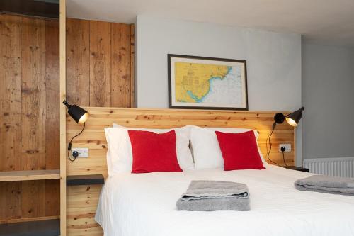 a bedroom with a large bed with red pillows at Rooms@Mourne in Dundrum