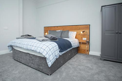 een slaapkamer met een groot bed met een houten hoofdeinde bij Rooms@Mourne in Dundrum