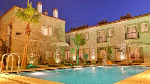 un hotel con piscina frente a un edificio en Jardin d'Azur Alaçatı, en Alacati