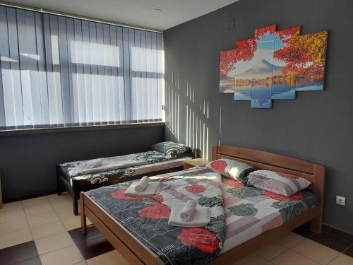 a bedroom with two beds and a painting on the wall at S Apartmani Priboj in Čitluk