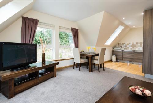 a living room with a television and a dining table at The Claymore Guest House in Pitlochry