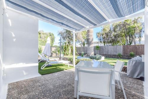 a white pergola with a table and chairs on a patio at Villas New Lanzasuites in Playa Blanca