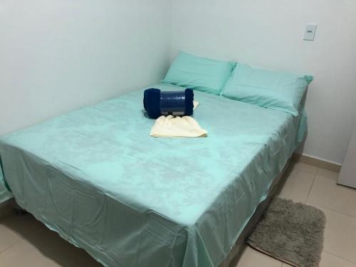 Una cama con una manta azul y una bolsa azul. en GREAT HOUSE, en Manaus