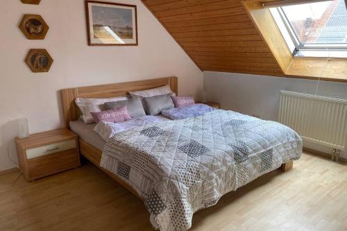ein Schlafzimmer mit einem Bett mit einer Bettdecke und einem Fenster in der Unterkunft Villa Ulla in Burgoberbach