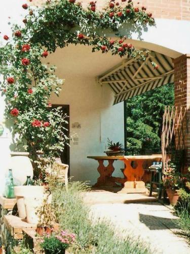 a patio with a table with roses on it at Agriturismo S.Lucia in Roccaforte Mondovì