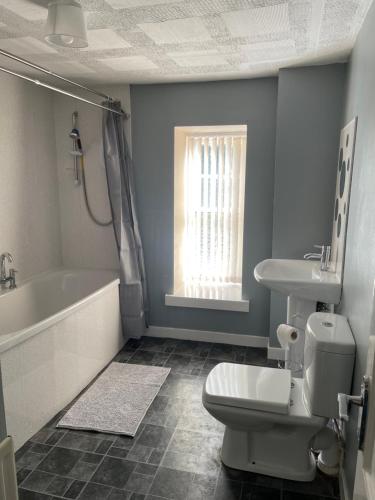 een badkamer met een bad, een toilet en een wastafel bij 1-2 Dialknowe Holiday Cottage - Wanlockhead in Wanlockhead