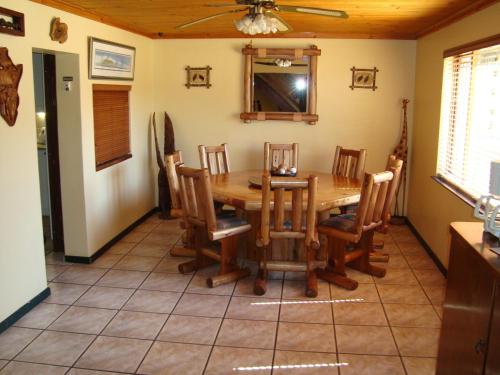 Un comedor con mesa y sillas de madera. en Pentzhaven Guesthouse, en Table View