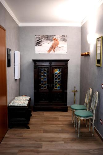 a waiting room with a table and chairs and a fireplace at La Casa Della Volpe in Vedano Olona