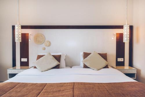 a bedroom with a large white bed with two pillows at Iberostar Selection Royal El Mansour in Mahdia