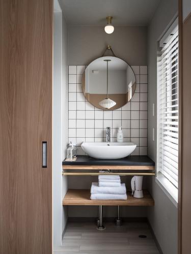 a bathroom with a sink and a mirror at RAKURO Kyoto by THE SHARE HOTELS in Kyoto