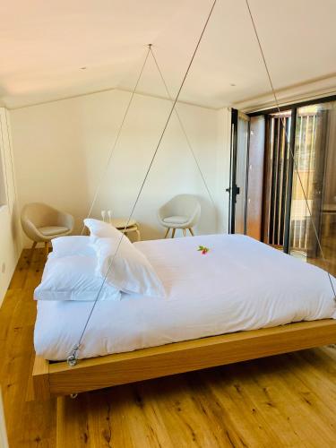 a bedroom with a large white bed with a swing at CASA DA TRINCHEIRA , turismo de habitação in Pinhel