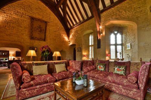 
a living room filled with furniture and a large window at Abbots Grange Manor House Hotel in Broadway
