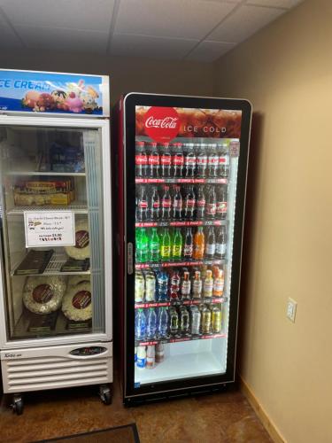 a soda machine and a refrigerator with sodas and drinks at AmericInn by Wyndham Fargo Medical Center in Fargo