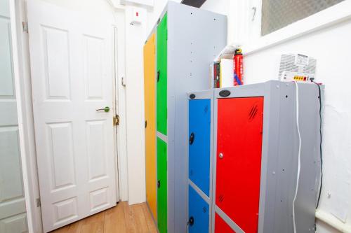 Zimmer mit bunten Schränken neben einer Tür in der Unterkunft Cosy Studio in the Heart of Trendy Kemptown in Brighton & Hove