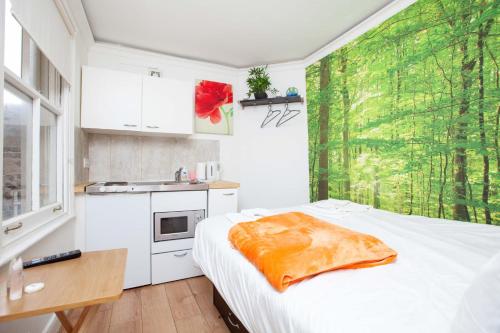 eine kleine Küche mit einem Bett in einem Zimmer in der Unterkunft Cosy Studio in the Heart of Trendy Kemptown in Brighton & Hove