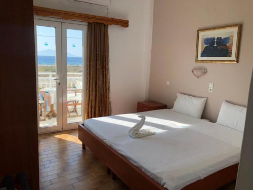 a bedroom with a bed with a view of a balcony at Anthoulis Studios in Kefalos