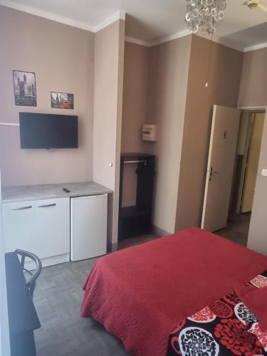 1 dormitorio con cama roja y manta roja en Hôtel des allées, en Marsella