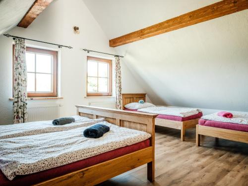 two beds in a room with two windows at Statek Humenec - Klid u lesů, Česko in Valašská Bystřice