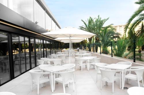
a patio area with chairs, tables and umbrellas at Prince Park in Benidorm
