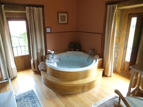 a large bathroom with a wooden tub in a room at Palacio Garcia Quijano in Los Corrales de Buelna