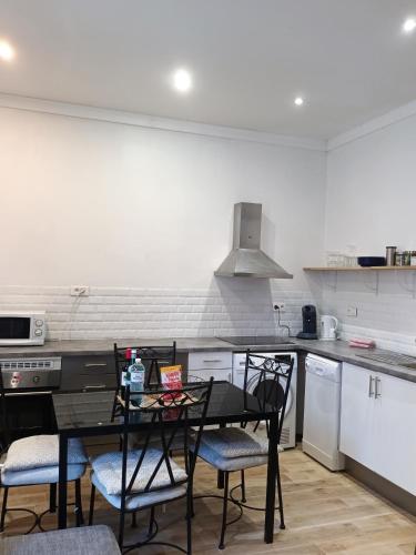 a kitchen with a table and chairs in a kitchen at Centre ville 10 min de la Croisette/Downtown in Cannes