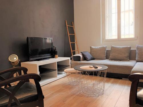 a living room with a couch and a tv at Centre ville 10 min de la Croisette/Downtown in Cannes
