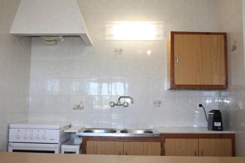 a kitchen with a sink and a stove at Precioso apartamento con piscina. in Pals