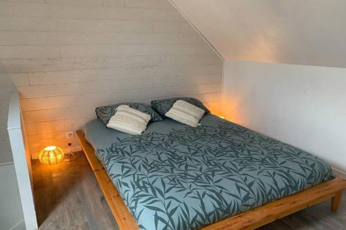 un lit avec deux oreillers dessus dans une chambre dans l'établissement LA PETITE MAISON PRÈS DE LA MER, à Fécamp