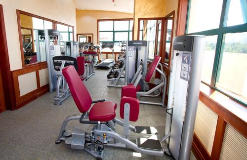 a gym with a row of tread machines and red chairs at Palace Hotel Arusha in Arusha