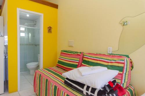 a bathroom with a bed with towels and a toilet at Pousada Recanto Dom Arthur in Itapema