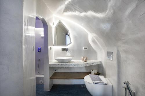 uma casa de banho branca com um lavatório e um WC em Blue White Residence em Monolithos