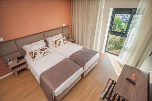 a hotel room with a large bed and a window at Essence Inn Marianos Hotel in Fátima