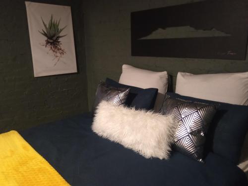 a bed with pillows and a white furry pillow at Maboneng City Building Free WiFi and Swimming pool in Johannesburg