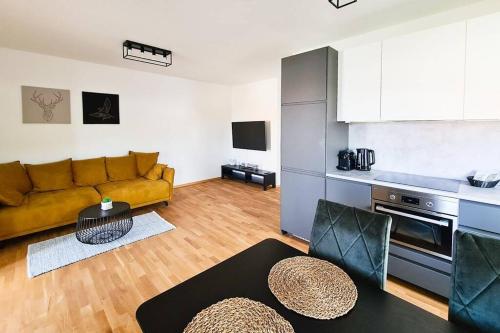 uma sala de estar com um sofá amarelo e uma cozinha em Friendship Suite em Mörbisch am See