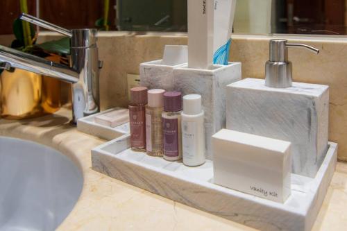 a bathroom counter with four bottles ofodorizers and a sink at FIRST CLASS 2BR with full BURJ KHALIFA and FOUNTAIN VIEW in Dubai