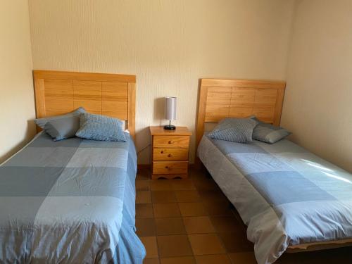 a bedroom with two beds and a lamp on a night stand at Sierra Norte in Canencia