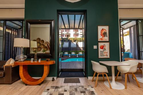 a living room with green walls and a table and chairs at Mountview Guest House in Cape Town
