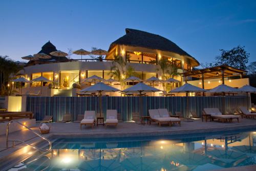 a hotel with a pool in front of a building at Grand Matlali Suites & Villas Riviera Nayarit in Cruz de Huanacaxtle