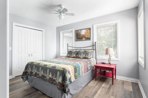 een slaapkamer met een bed en een rode tafel bij Bissell Creek Woodside Cottage in Williamsburg