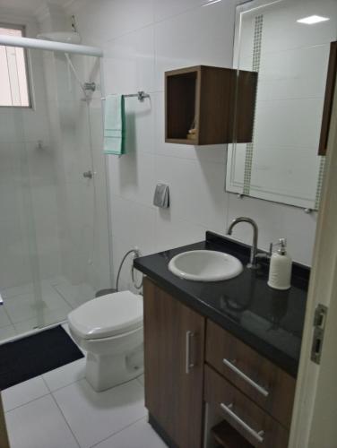 a bathroom with a toilet and a sink and a shower at Pé na areia, quadra mar. Perto de tudo em Balneário Camboriú! in Balneário Camboriú