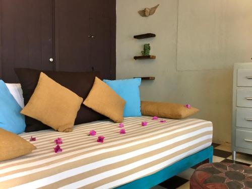 a bed with colorful pillows and flowers on it at Unique Studio Beach RG4 in Puerto Vallarta