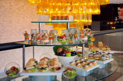 a display of sandwiches and salads and other food items at Mövenpick Hotel Jumeirah Lakes Towers Dubai in Dubai