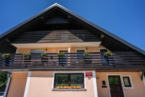 a house with potted plants on the balcony at Apartmaji Gorenc in Bohinj