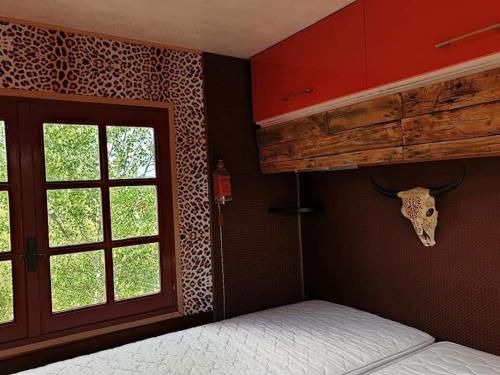a bedroom with a bunk bed with a cow skull on the wall at Gîtes Les Perouilles - La loge climatisée de Naïda in Puymiclan