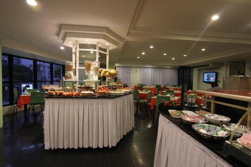 ein Restaurant mit Buffet mit Speisen in der Unterkunft Gonzaga Flat in Santos