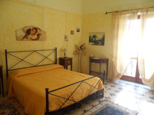 1 dormitorio con 1 cama con sábanas amarillas y ventana en B&B Il Vecchio Messina, en Trapani