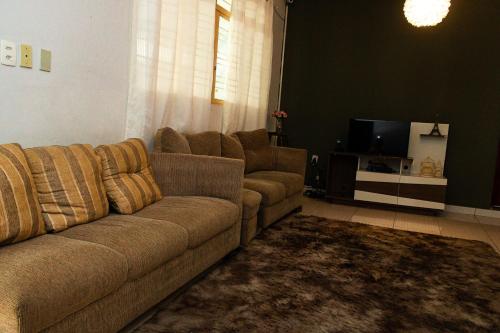 uma sala de estar com um sofá e uma televisão em Cacau Hostel em Goiânia