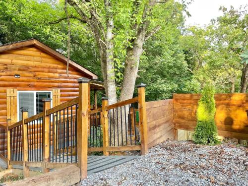 a wooden fence in front of a log cabin at New Tiny cabin Hot tub Firepit Fenced yard in Sevierville
