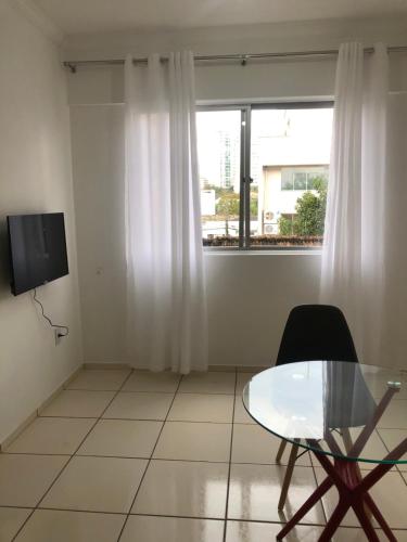 a living room with a glass table and a window at Abdon Batista - Apto completo central, Smart TV in Joinville