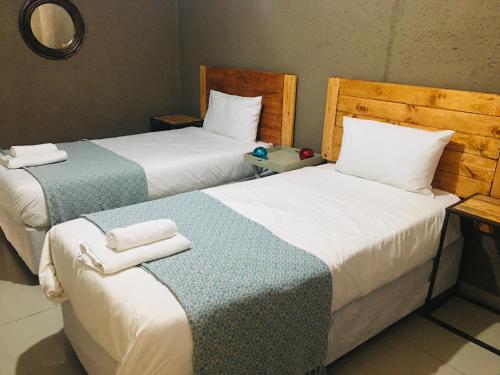 two beds sitting next to each other in a room at Asante’s Guest House in Calcutta